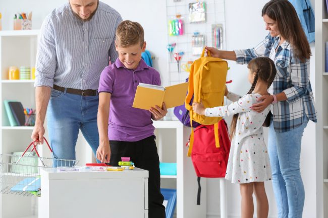 Children with parents choosing school stationery in store